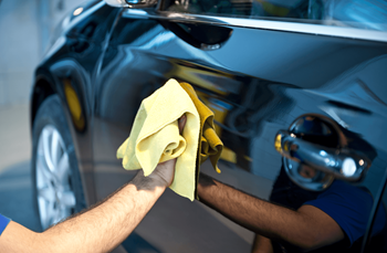 a man cleaning a car with a microfiber cloth
